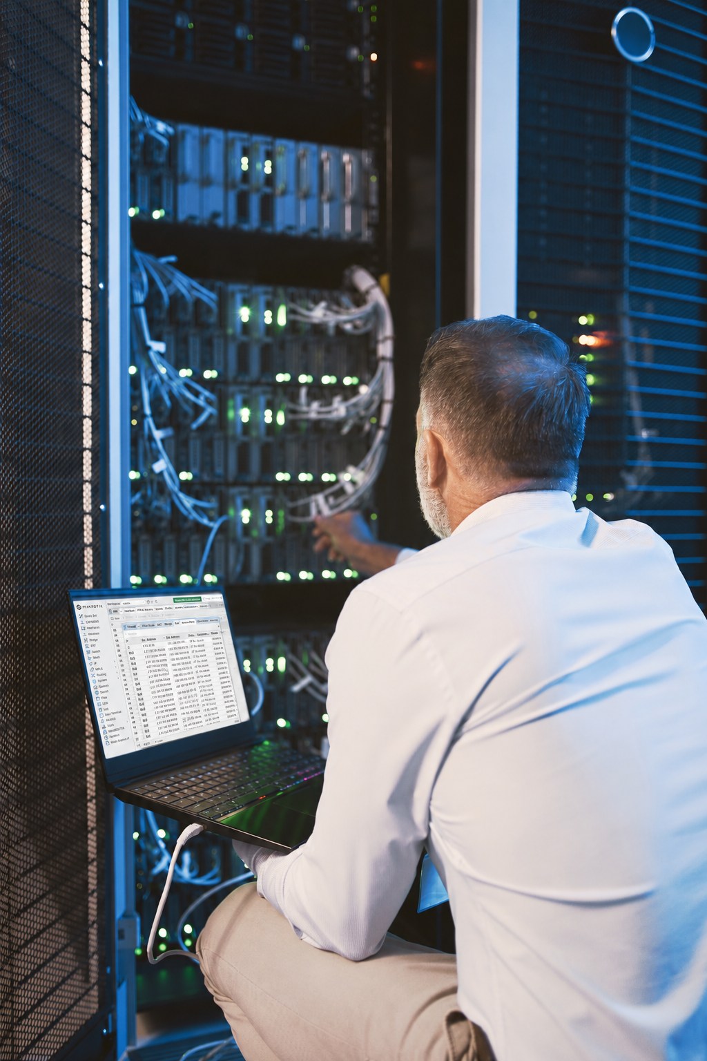 Técnico trabajando en servidores con la interfaz de MikroTik en su notebook